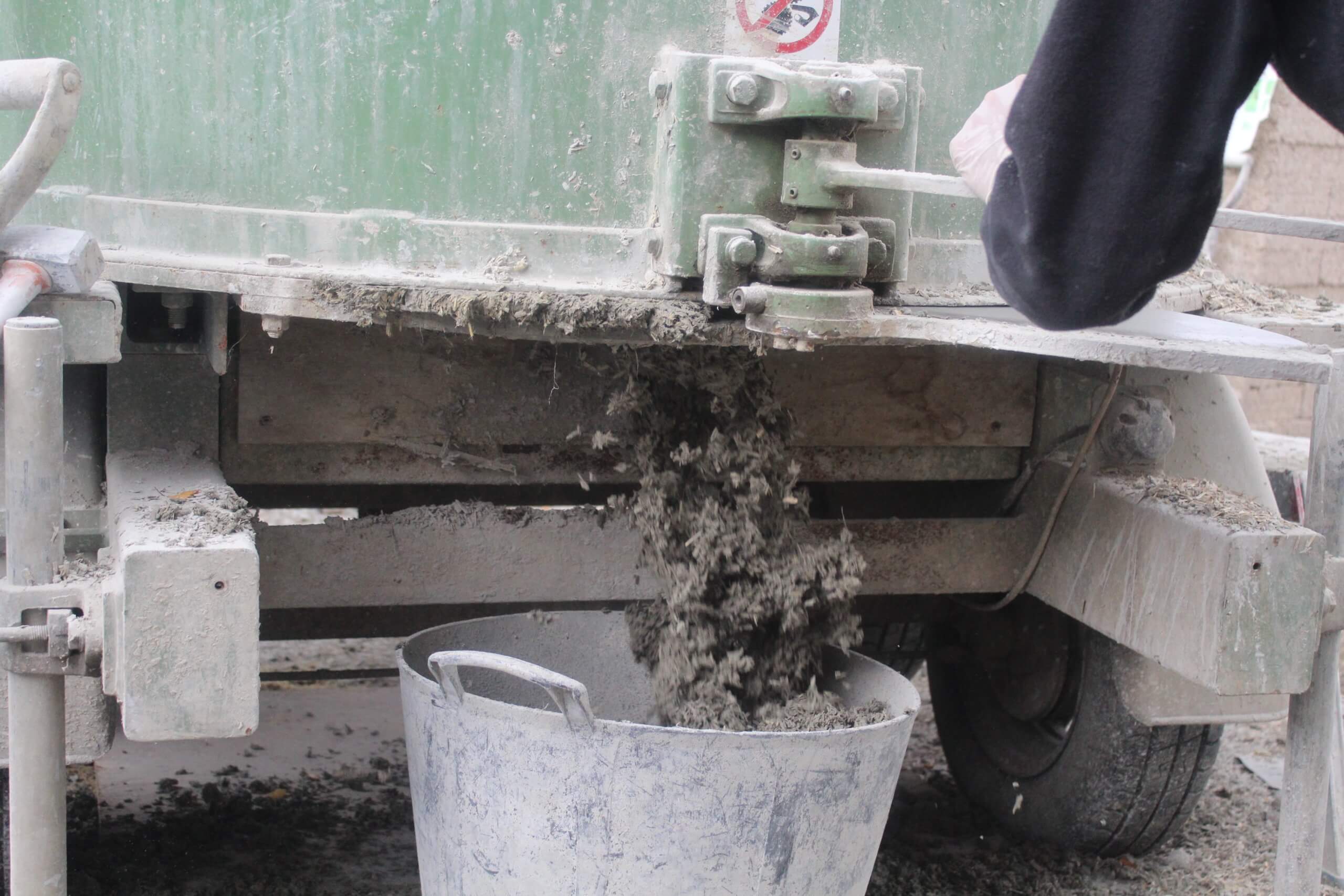 emptying hempcrete from a pan mixer into a flexible tub ready for placement between shutters