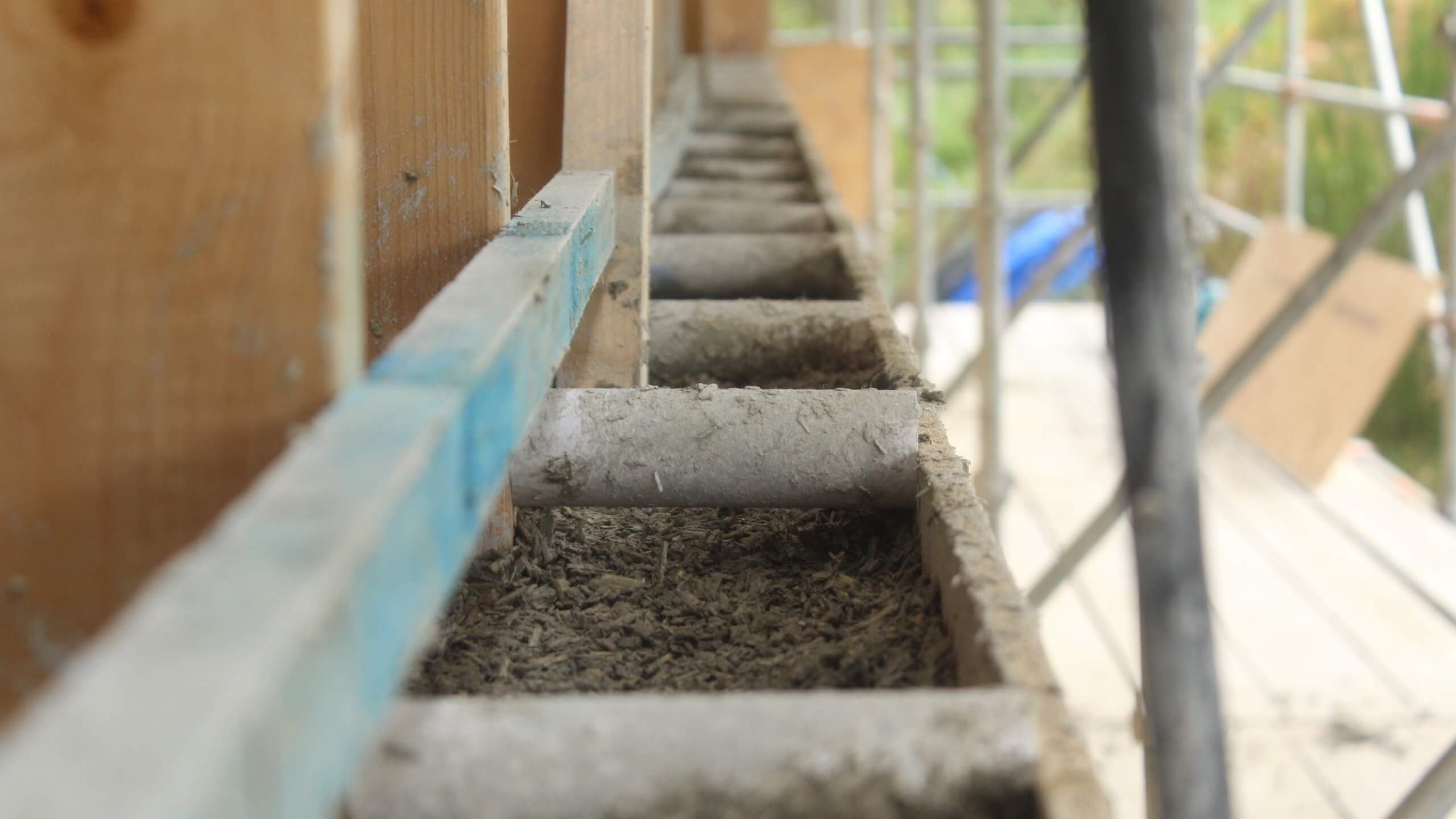 hempcrete wall with plastic spacers setting position of OSB shuttering. Horizontal treated timber rail against timber frame for hempcrete to wrap around