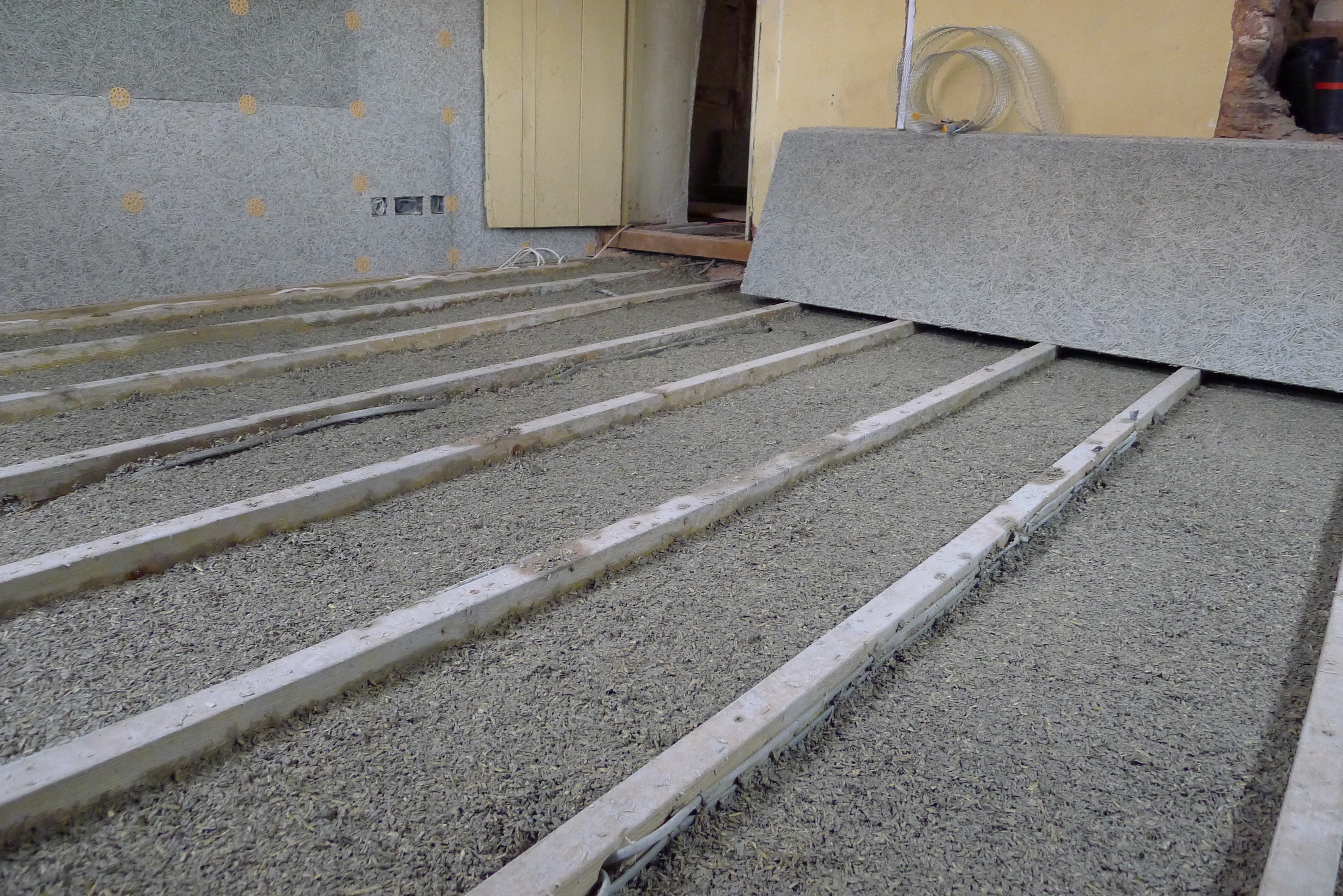 hempcrete cast between floor joists with service void before installation of floor finish