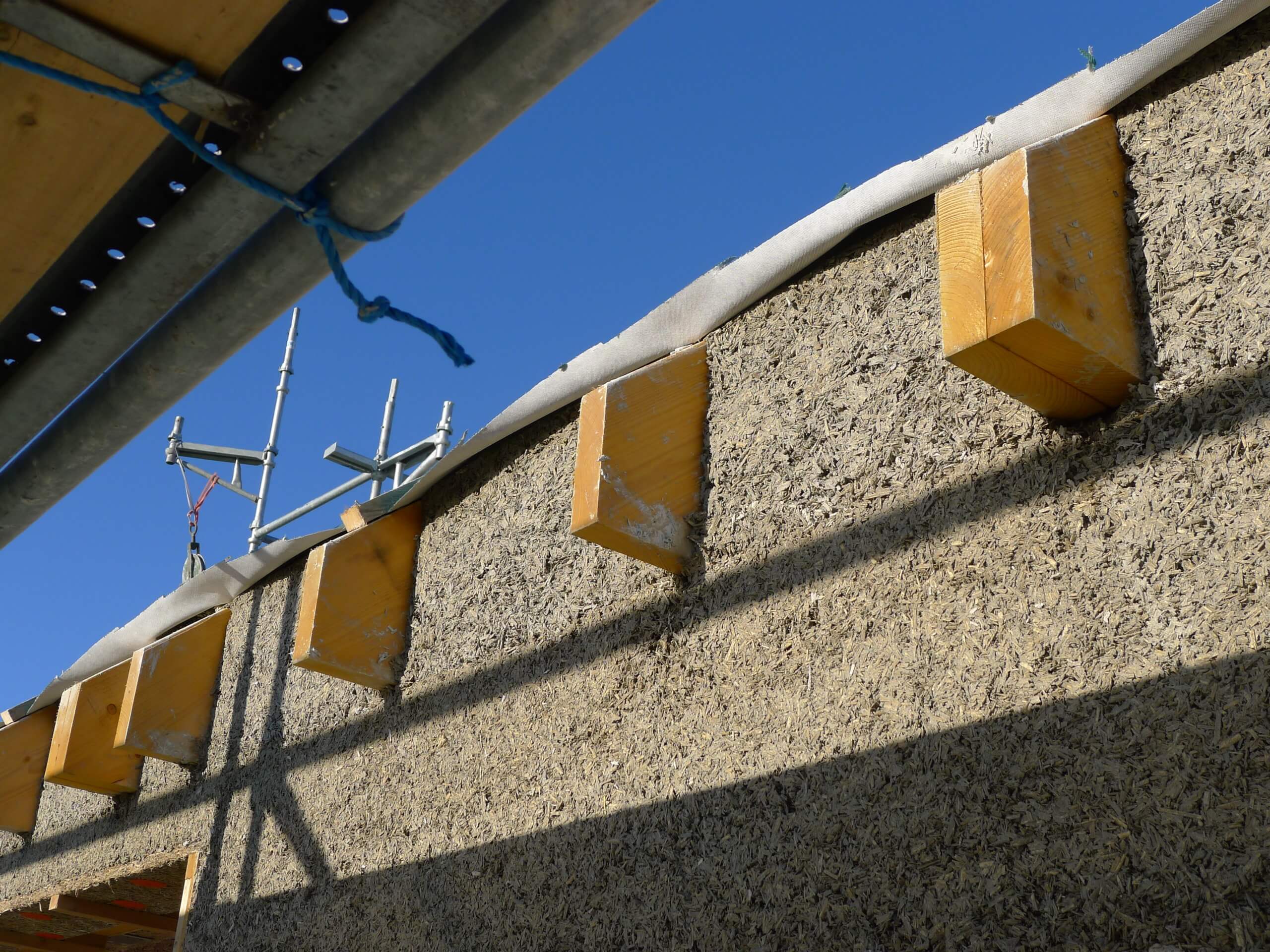 hempcrete wall at eaves height showing wall reaching the top of the roof rafters and temporary roofing membrane