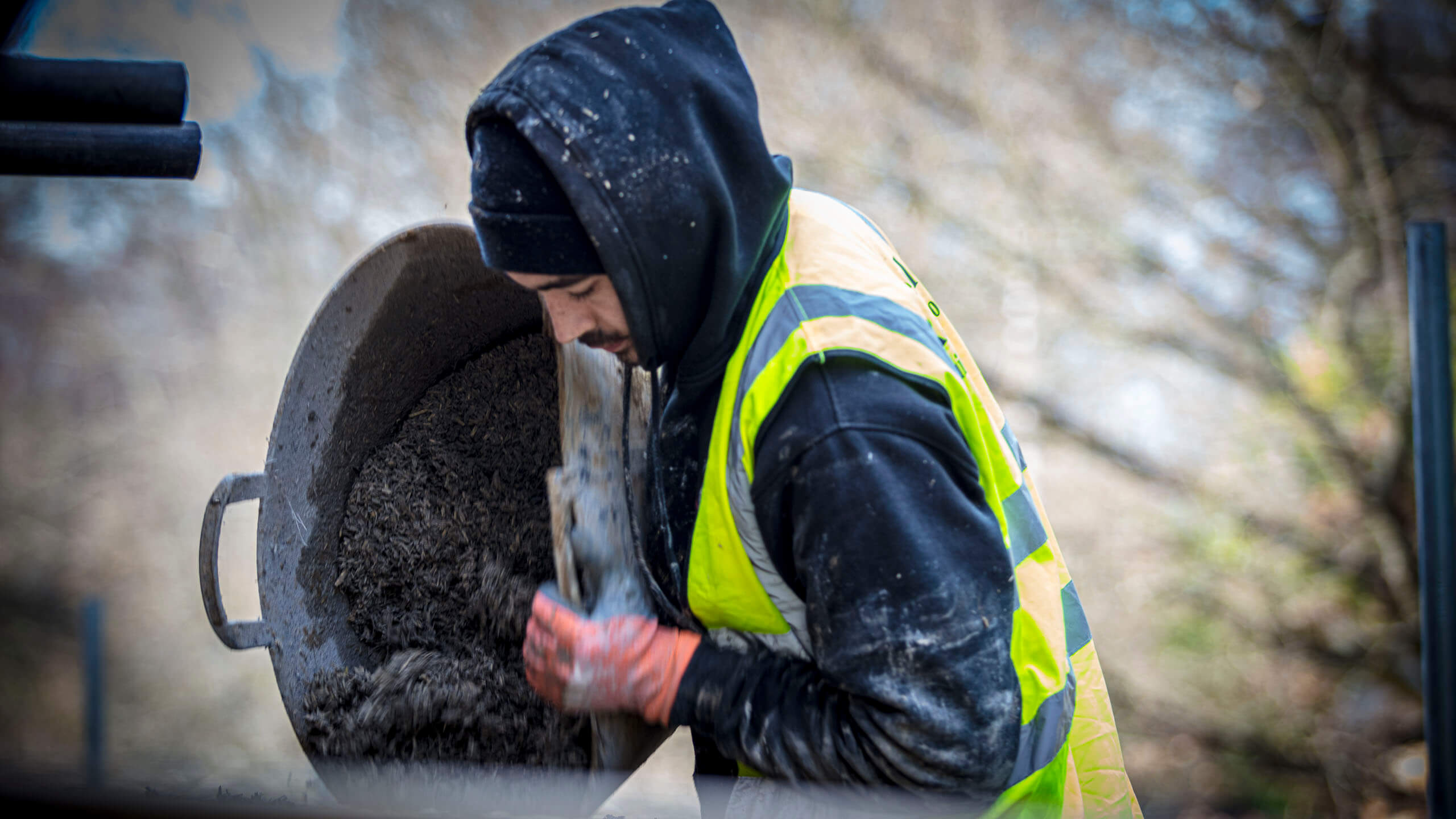 Man pouring hempcrete into shuttering ready on site